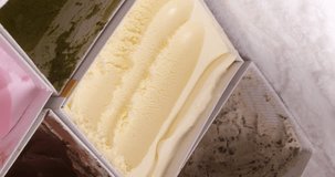 4K footage vertical video Front view CU, Scoop vanilla ice cream in the freezer.