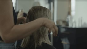 Rack focus of hairdressers styling hair of customers in salon, cedar hills, utah, united states