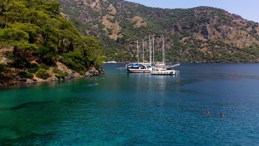 Gocek, Fethiye Muğla, Turkey A sailing yacht in Gocek, on Turkey's Aegean coast. Gocek is known for its pristine turquoise waters, remote beaches and historical ruins. Royalty-Free Stock Footage #1106010945