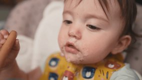 baby dirty eats. happy family toddler concept. baby girl learns to eat with her hands dirty dream her face dirty funny video dirty. baby on the table for feeding eats with her hands from cup