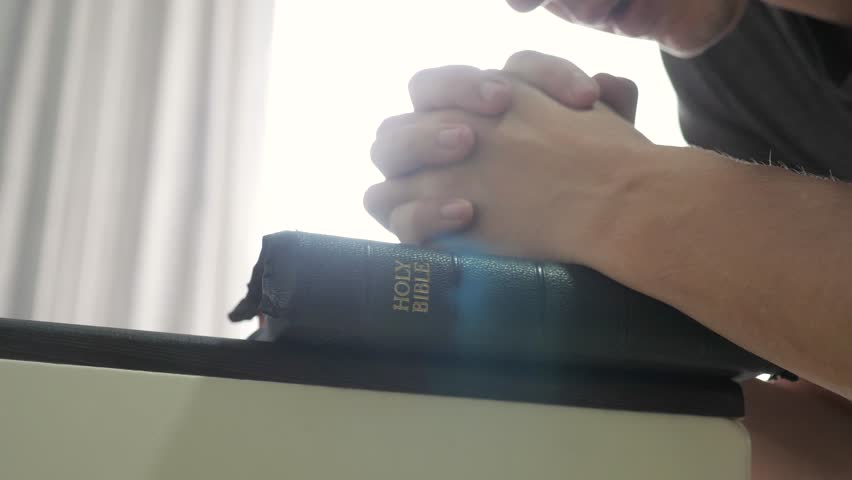 man praying indoors bedtime on bible. religion concept evening prayer human brunette hands lifestyle bible praying by bed Royalty-Free Stock Footage #1106014385
