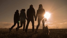 happy family and dog silhouette walking sunset teamwork. group of people friends walking holding hands slow motion video lifestyle. Teamwork happy family party and pet concept - Powered by Shutterstock - Get 15% off with code: PIKWIZARD15