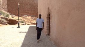 Video portrait of a male, person of color, in his thirties exploring and sightseeing the beach and the vibrant streets of the historic Medina in Rabat, Morocco, North Africa