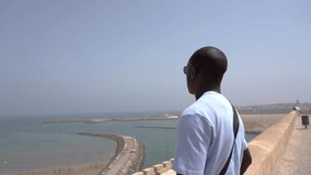 Video portrait of a male, person of color, in his thirties exploring and sightseeing the beach and the vibrant streets of the historic Medina in Rabat, Morocco, North Africa