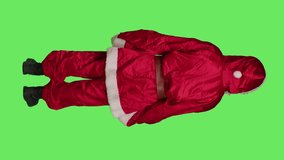 Vertical video Back view of christmas embodiment character shows palm as stop sign, rejecting ideas and acting displeased over full body greenscreen. Santa claus doing no symbol to refuse something