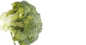 4K footage vertical video Front view SLO MO CU, Fresh green broccoli swirls on white background.