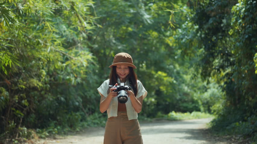 Asian woman traveller enjoy vacation moment while taking photos of nature with camera, Female hands holding camera and doing nature photography, Travel Blogger Photographing.
