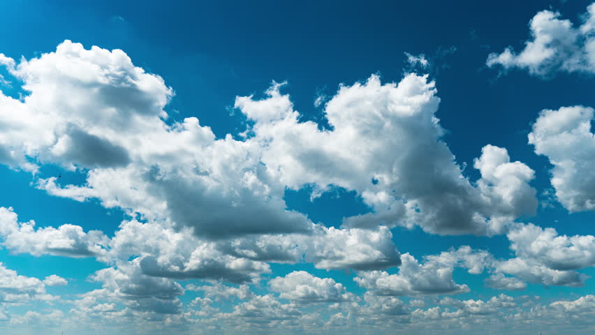 White fluffy clouds slowly float through the blue daytime sky timelapse. Beautiful skies are moving. Airy snow-white clouds move to the side. Royalty-Free Stock Footage #1106028373