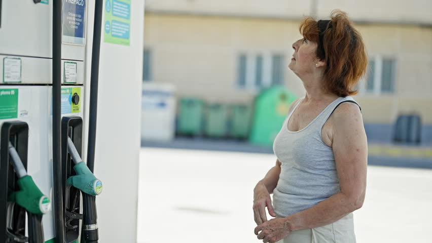 Middle age woman thinking at petrol station