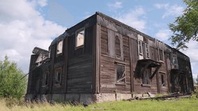 Old abandoned wooden house in village. Clip. Wooden house stands abandoned and destroyed in steppe. Beautiful abandoned wooden house without roof and windows in summer