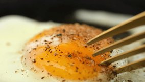 Eating frying egg. Cutting the egg yolk with a fork, the egg yolk flows out. Healthy breakfast or lunch - Powered by Shutterstock - Get 15% off with code: PIKWIZARD15