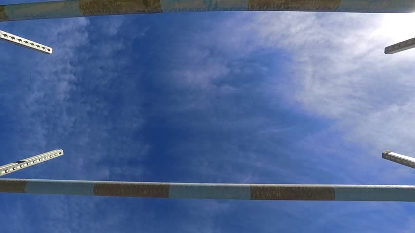 Jump over obstacles. Close-up on horse hooves.
Slow motion shot of the horse jumping from below.