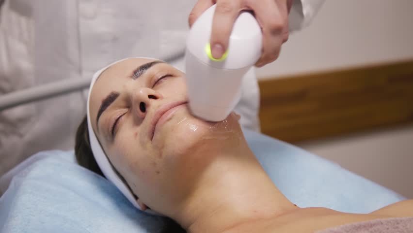 Brown haired woman receiving radiofrequency lifting procedure around eyes for her face skin rejuvenation at aesthetic cosmetology center Royalty-Free Stock Footage #1106056705