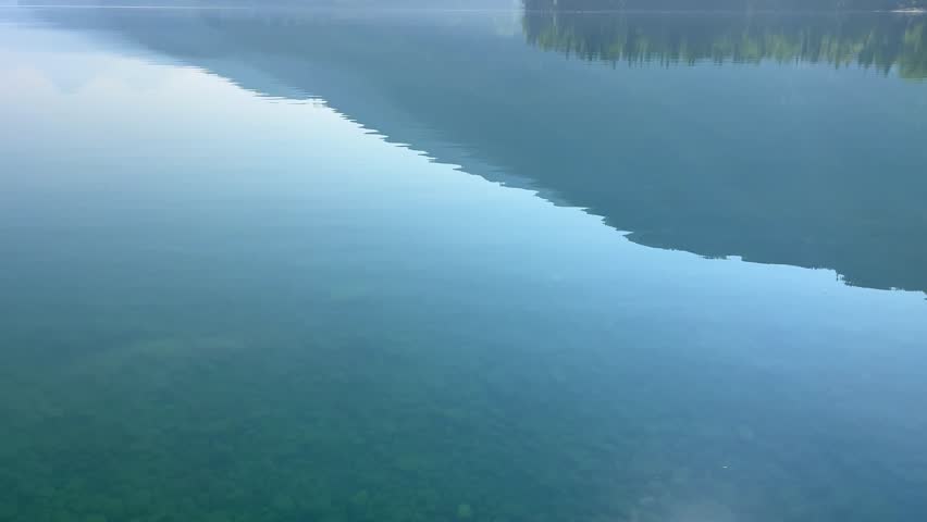 Panning up on beautiful Lake McDonald in Glacier National Park by West Glacier in Montana on a hazy  day.