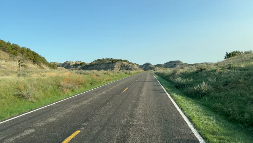 Driving through the badlands hills and mountains in Theodore Roosevelt National Park in North Dakota.
