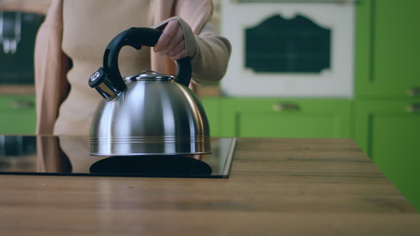 Amazing design kitchen closeup to the camera woman in the morning put the kettle over the electric stove and get ready to take the breakfast and go to work