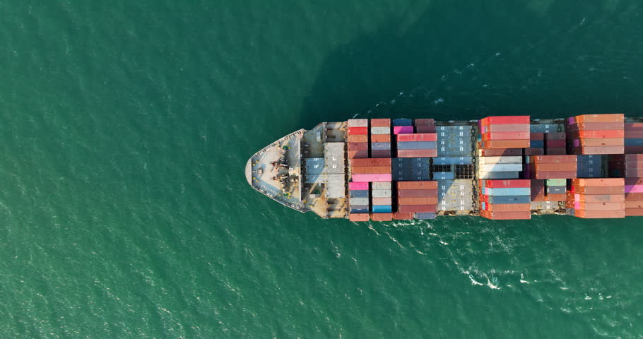 Cargo container ship full speed sailing in sea import export goods and distributing products to dealer and consumers across worldwide by container ship Transport 4k video drone point of view  | Shutterstock HD Video #1106063553