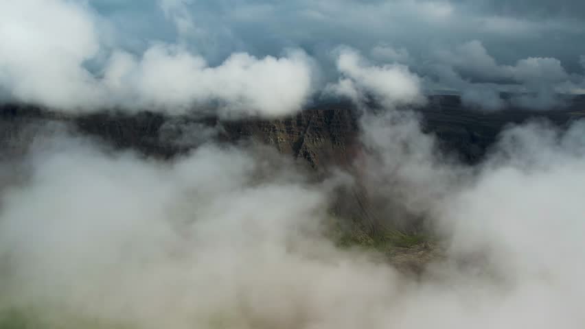 Aerial view of a mountain landscape with low clouds and fog in inner highlands of Iceland.