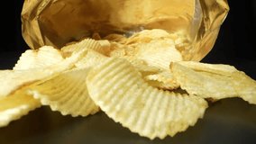 A captivating macro video captures the intricate details of a probe lens slowly gliding into a bag of potato chips, revealing the mesmerizing textures and colors of the chips up close. 4K
