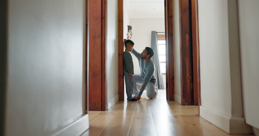 Measure, growth and dad writing on wall with child in family home, door frame and measuring height, measurement or progress results. Father, pride in son and check development together in a house Royalty-Free Stock Footage #1106085249