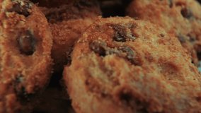 A macro close up zoom in cinematic shot of a plate full of crispy juicy chocolate chip cookies, on a rotating stand, studio lighting, slow motion, smooth movement, 4K video