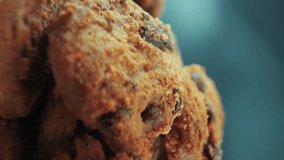 A vertical macro close up cinematic shot of a plate full of crispy chocolate chip cookies, on a rotating stand, studio lighting, slow motion, smooth movement, 4K video