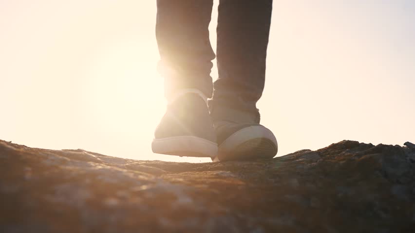 baby boy playing in mountains rocks park. close-up child feet walking on mountains rocks. happy family kid dream concept. a child in sneakers walks on mountains rocks lifestyle park
