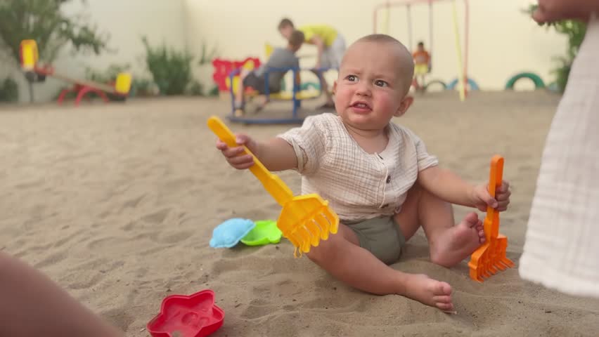 baby group playing in sandbox. happy family kid dream concept. baby sits on the sand plays toys development of fine motor skills training. group of children in kindergarten playing lifestyle Royalty-Free Stock Footage #1106086921