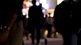 SHIBUYA, TOKYO, JAPAN - MAY 2023 : Slow motion shot of crowd of people walking at Shibuya crossing at night. Busy downtown area in Tokyo. Japanese people, urban city life and metropolis concept video.