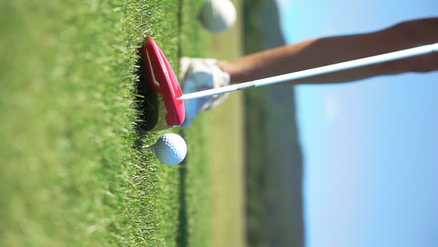 Mature woman playing golf. Female golfer hitting golf shot. Beautiful sunny landscape, with green hills and blue sky.