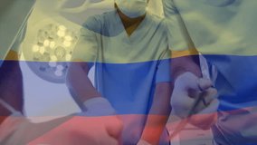 Animation of waving colombia flag over team of diverse surgeons performing surgery at hospital. Medical healthcare and patriotism concept - Powered by Shutterstock - Get 15% off with code: PIKWIZARD15