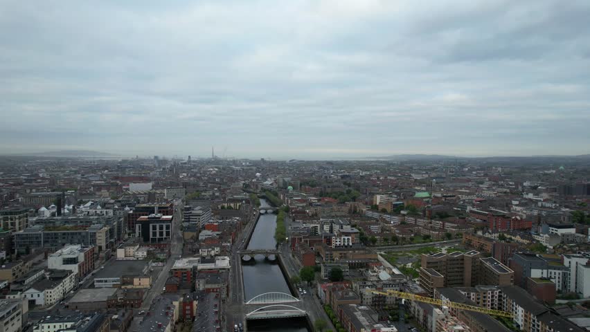 Backward drone shot of downtown Dublin with bridges across River Liffey