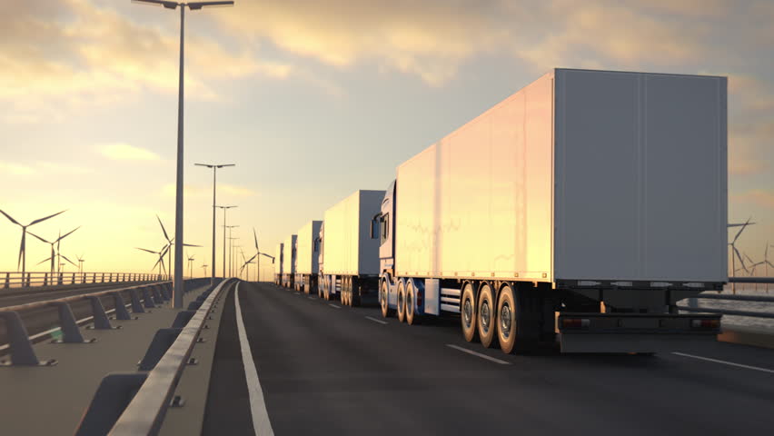 Convoy of generic electric semi trucks with cargo trailer driving along a bridge or coastal highway with wind turbines in background. Renewable energies concept. Realistic 3d rendering animation. Royalty-Free Stock Footage #1106096601