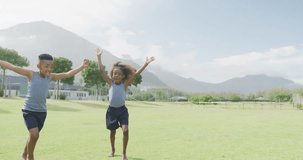 Video of happy african american schoolchildren high fiving in field after football game. Education, childhood, inclusivity, health, sport, elementary school and learning concept.