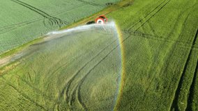 Video with a drone of an irrigation and sprinkling system on an agricultural field with colorful rainbow in hot summer, Germany