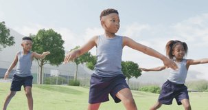 Video of three african american schoolchildren practicing yoga standing in outdoor class. Education, childhood, inclusivity, health, sport, elementary school and learning concept.