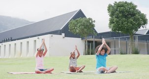 Video of diverse schoolgirls and schoolboy practicing yoga meditation in outdoor class, copy space. Education, childhood, inclusivity, health, elementary school and learning concept.