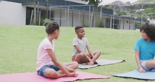 Video of diverse, happy schoolgirls and schoolboy talking during outdoor yoga class, copy space. Education, childhood, inclusivity, health, elementary school and learning concept.