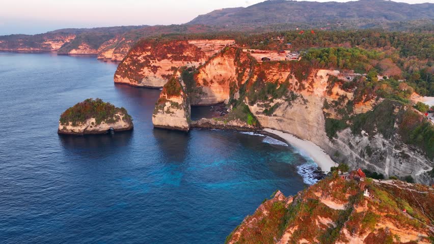 Beautiful aerial view of tropical beach on an island of Nusa Penida at sunrise, paradise Indonesian beach, amazing Bali coastline, holiday tourist destination. High quality 4k footage