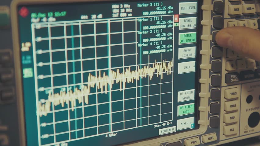 Hand held close up shot of spectrum analyzer screen with megahertz decibels and other readings, finger push buttons | Shutterstock HD Video #1106111061