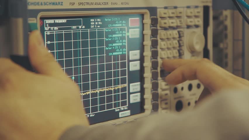 Hand held close up shot of spectrum analyzer screen with megahertz decibels and other readings and lots of buttons | Shutterstock HD Video #1106111067