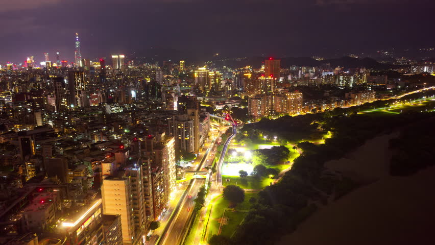 Night skyline of Taipei, the capital city of Taiwan, with Guting Bikeway Bridge Observation Deck by an elevated expressway and 101 Tower among high rise buildings and dazzling lights in Xinyi District