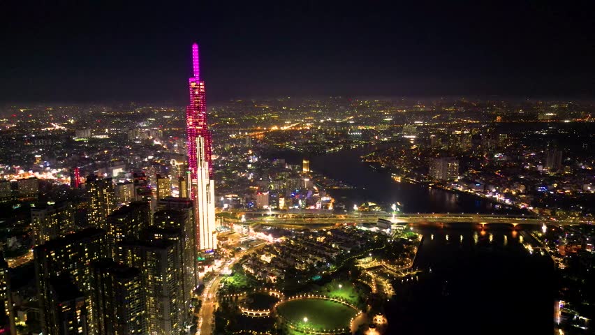 Aerial view of a Ho Chi Minh City, Vietnam with development buildings, transportation, energy power infrastructure. Financial and business centers. Sunset to night. Travel and landscape concept. 4K