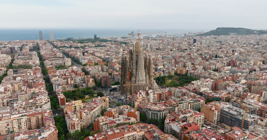 La Sagrada Familia, residential area of Barcelona, Spain Eixample residential district. Architectural heritage country at sunrise in summer on aerial view slide from drone turn. Go Everywhere. Travel Royalty-Free Stock Footage #1106123377