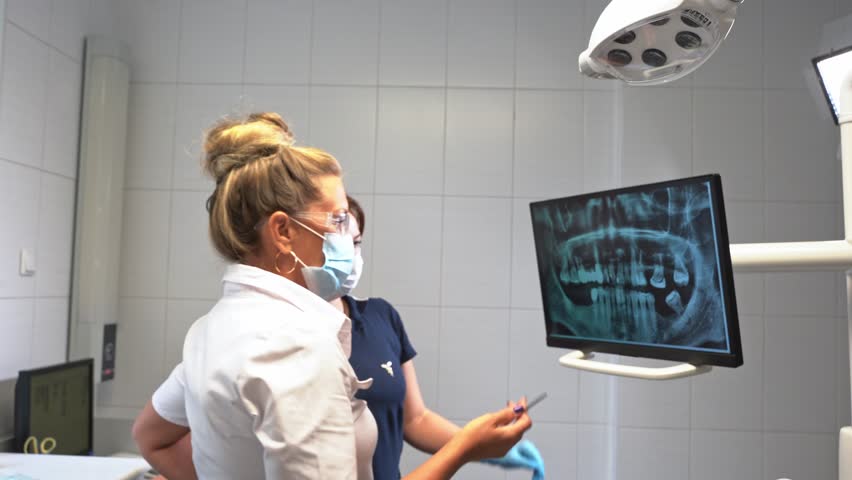 Dentist hand explore study teeth mouth cavity x-ray on monitor describe therapy to patient at dentistry office over. Oral hygiene orthodontic treatment, examination of health tooth care Royalty-Free Stock Footage #1106123765