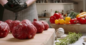 Chef prepares blanks for meatballs from fresh minced meat in kitchen with subdued lighting, Professional promotional video Advertising. Chef cook minced meat for burger. Home calm cooking food gourmet
