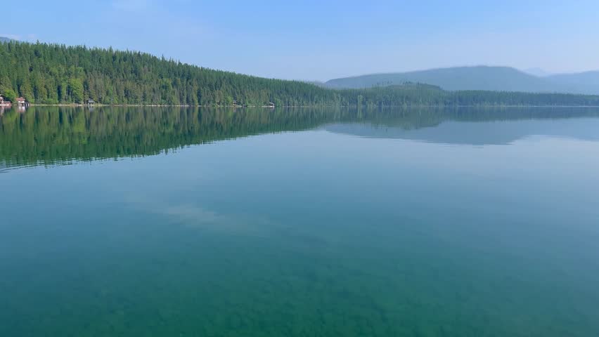 Panning left on beautiful Lake McDonald in Glacier National Park by West Glacier in Montana on a hazy  day.