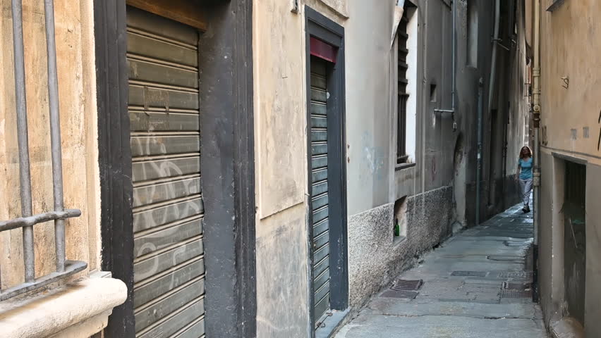 Genoa, Liguria, Italy. 3 june 2023. Fascinating footage of an alley in the historic centre, called caruggio in the local language. A middle-aged woman explores it, discovering glimpses of Genoa.
