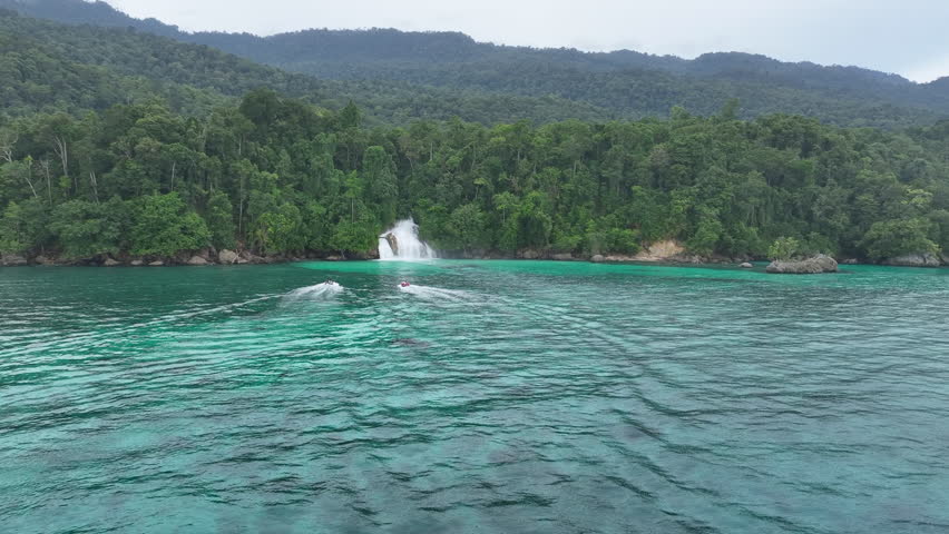 The beautiful Momon waterfall tumbles from the primordial rainforest of West Papua into the shallow sea. This spectacular waterfall is found about a day