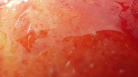 Captivating macro video showcases a Jazz apple glistening with tiny droplets of water, highlighting its vibrant colors and tempting juiciness. Fruit concept. Apple background. 4K UHD
